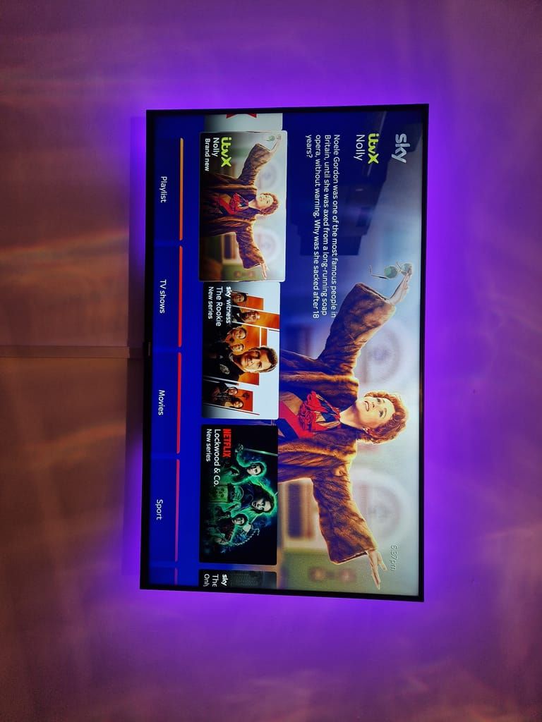 TV with purple LED backlighting showing Sky interface