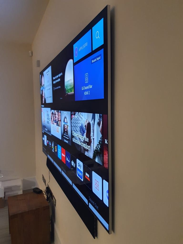 Large TV wall mounted with LG sound bar