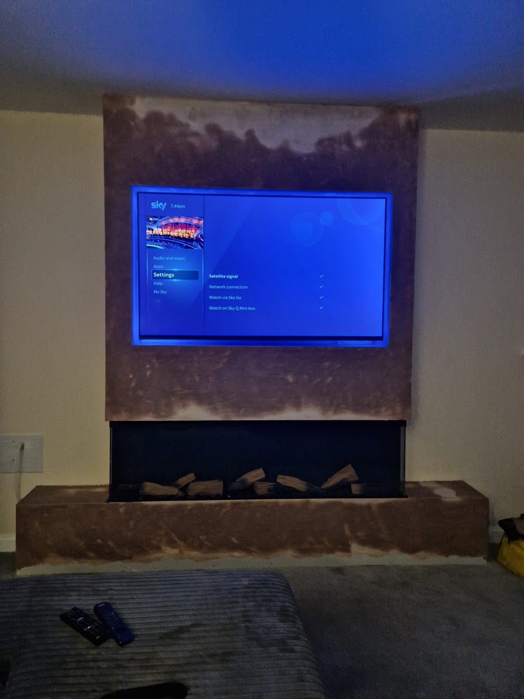 TV mounted above electric fireplace in bedroom