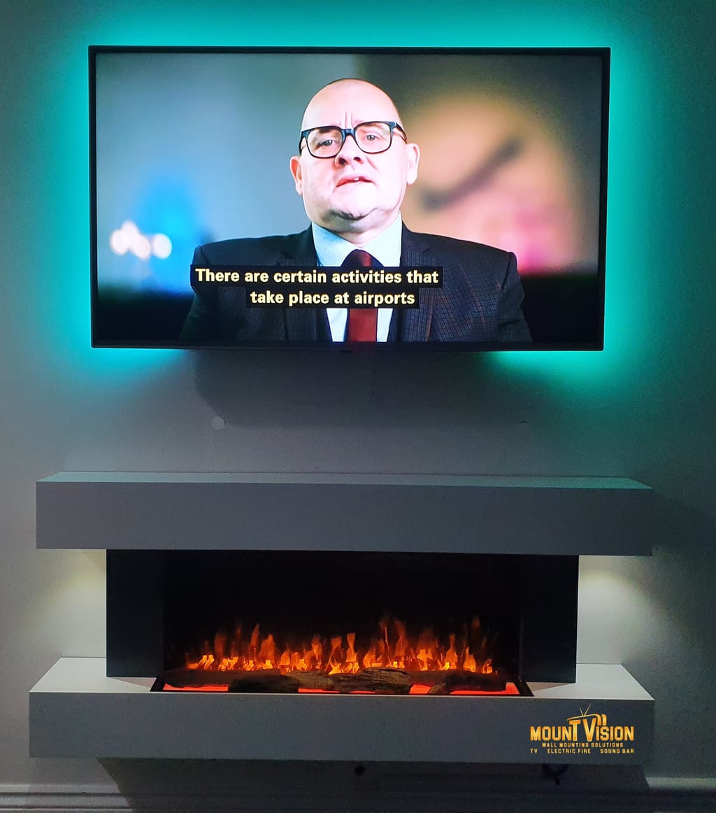 TV above modern fireplace with turquoise LED lighting